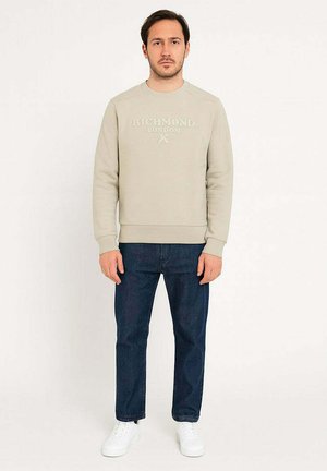 Felpa grigia chiara con testo in rilievo "RICHMOND LONDON", abbinata a jeans scuri e sneakers bianche. Tessuto liscio, design con collo a giro.