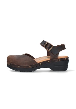 Sandalo sabot in pelle marrone con cinturino regolabile alla caviglia, borchie metalliche lungo la suola e tacco basso nero.