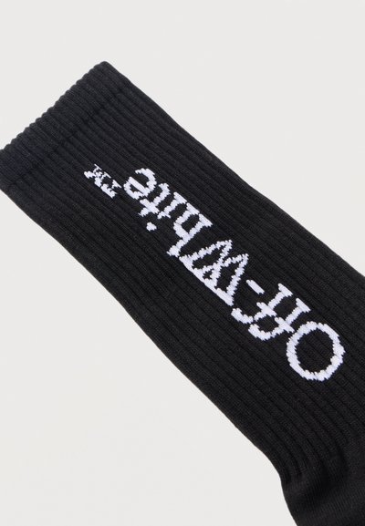 Μαύρη ριμπ κάλτσα με λευκό κείμενο "Off-White™" πλεγμένο κατά μήκος της πλευράς.