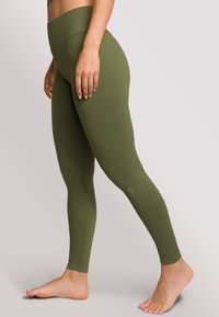 Olivengroene geribde leggings met een hoge tailleband, met een aansluitende pasvorm en een gladde, rekbare textuur.