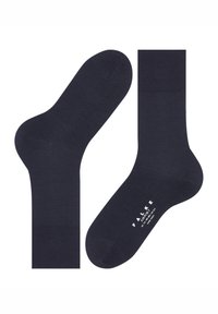 Čarape tamnoplave boje od mješavine pamuka, gornji dio rebrast, glatke teksture, zaobljeni vrh, s bijelom etiketom s nazivom brenda na donjoj strani.