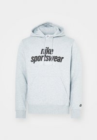 Grey cotton hoodie featuring a kangaroo pocket and drawstring hood. Black "nike sportswear" logo prominently displayed on the front.