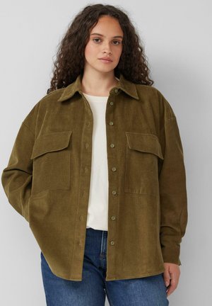 Chemise en velours côtelé vert olive à manches longues, avec deux poches poitrine et un devant à boutons. Coupe décontractée, matériau texturé et couleur unie.