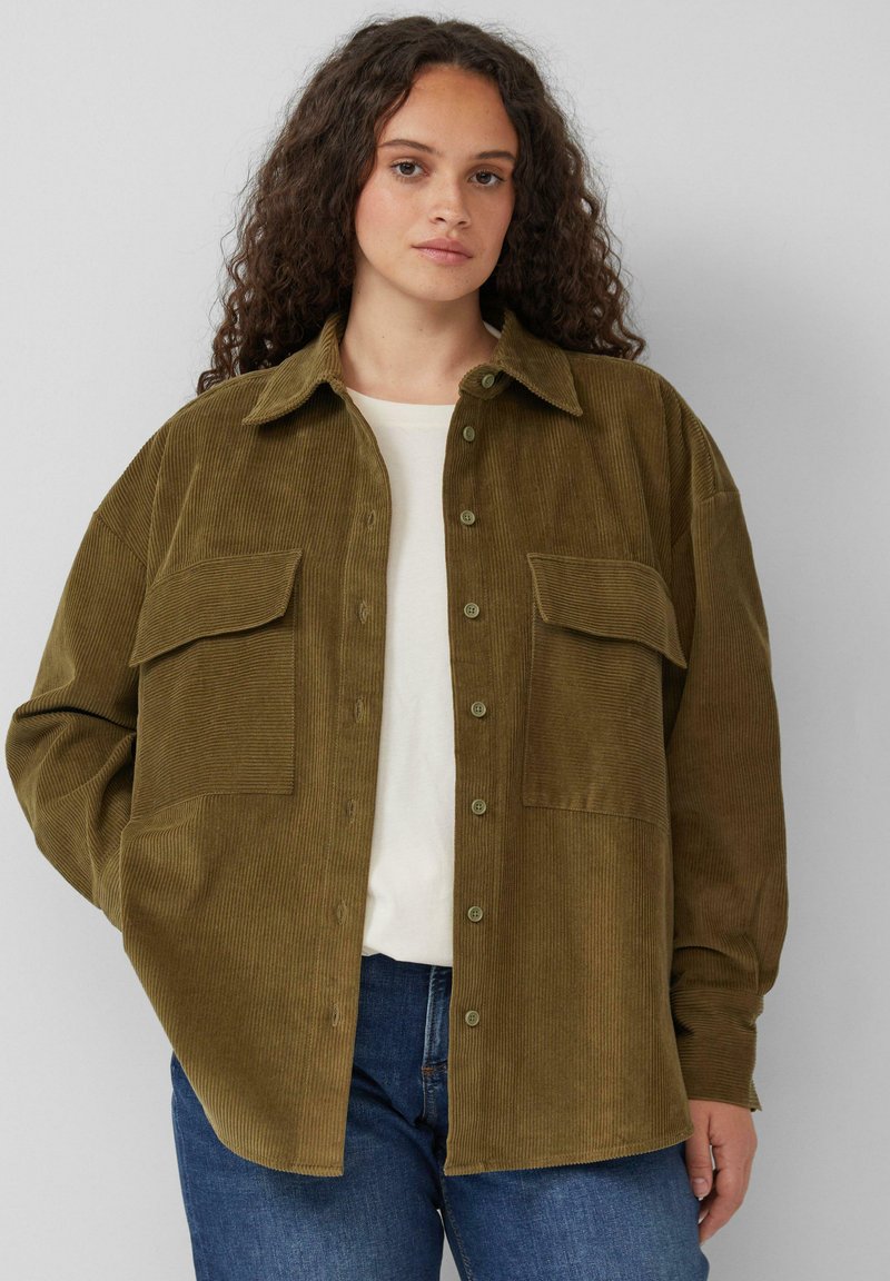 Olijfgroene corduroy overhemd met lange mouwen, twee borstzakken en knoopsluiting aan de voorkant. Relaxte pasvorm, gestructureerd materiaal en effen kleur.