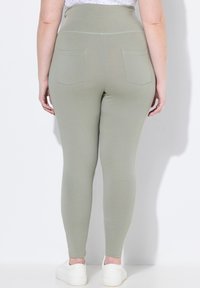 Vysoké světle zelené legíny s hladkou texturou, které mají dvě zadní kapsy a přiléhavý střih až k ankletům.