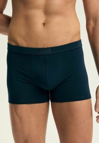 Męskie bokserki w kolorze granatowym, wykonane z miękkiego materiału, o dopasowanym kroju, elastycznym pasku w talii i gładkiej fakturze bez wzorów.