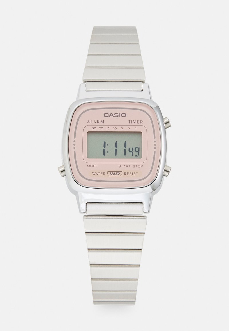 Montre numérique avec un bracelet en acier inoxydable argenté, un cadran rectangulaire rose et un affichage gris montrant l'heure ainsi que des icônes pour l'alarme et le chronomètre.