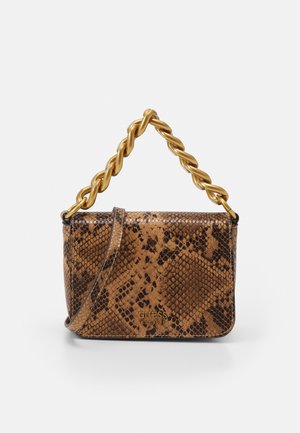 Sac à main Guess marron et noir à motif peau de serpent, avec une anse supérieure tressée dorée et une longue bandoulière sur fond blanc.