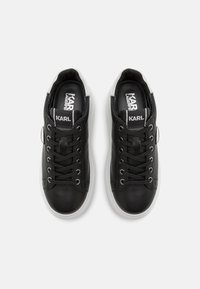 Sorte lærersneakers med tonet snøring, hvite gummisåler og grå accenter på hælen. Logo trykt på tungen og siden.