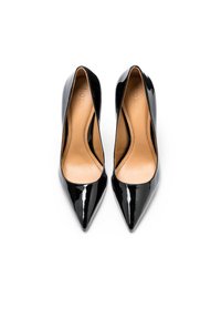 Paire d'escarpins noirs en cuir verni à bout pointu, avec semelles intérieures beige, vus de dessus sur fond blanc.