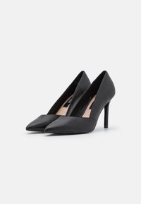 Černé lodičky na vysokém podpatku s špičatou špičkou a elegantním designem. Vyrobené z hladké kůže, s taperovanou siluetou a tenkým stiletto podpatkem.