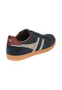 Sneaker in suede blu scuro con strisce grigie, accenti bordeaux e suola in gomma. Logo dorato esposto sul lato e dettagli di cucitura distintivi.