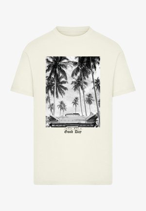 T-shirt crema in cotone con una grafica in bianco e nero di palme e una macchina d'epoca, con il testo "Oggi è stata una bella giornata" sottostante.