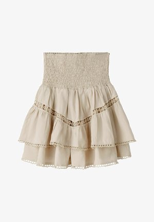 Béžová vrstvená mini sukňa s naberaným vysokým pásom, krajkovými detailmi a dvojitými volánmi na jednoduchom bielom pozadí.
