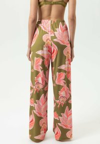 Bloemen wijde broekspijpen in olijfgroen met grote roze en koraalroze bloemenpatronen. Elastische tailleband en een gladde, lichte stof.