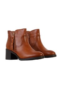 Bottes basses en cuir marron avec fermetures éclair latérales, tirettes tressées et talons blocs noirs sur fond blanc.