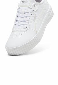 Sneaker bianco con tomaia in pelle liscia, suola testurizzata e rilievi prominenti. Presenta punta rotonda, dettagli perforati e linguetta con marchio.