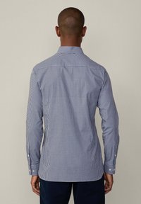 Navy and white checked button-up shirt with long sleeves, standard collar, and fitted design. Features contrasting buttons and a smooth texture.