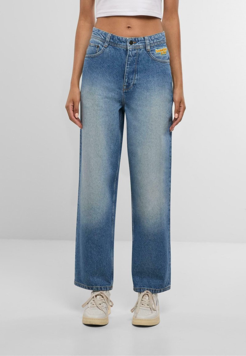 Plaša nagu zila denima džinsi ar izmītu mazgāšanu, ar priekšējām kabatām, pogu aizdari un zīmola uzlīmi netālu no jostasvietas.