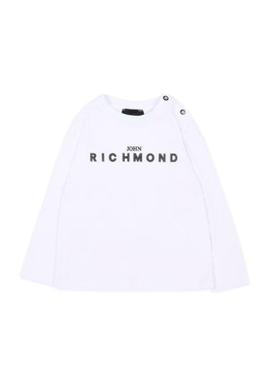 Camicia bianca a maniche lunghe con la scritta "JOHN RICHMOND" in lettere nere decorative sul petto e due bottoni neri sulla spalla sinistra.