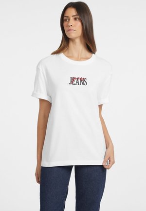 T-shirt bianco in cotone con stampa grafica con le parole "Jeans" in nero e rosso. Maniche corte e scollatura rotonda. Vestibilità casual.