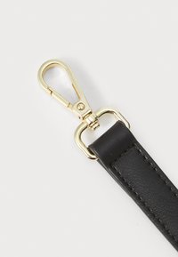 Svart kunstlær stropp med en gull metallsnapphook. Stroppe har en jevn tekstur og detaljerte sømmer langs kanten.