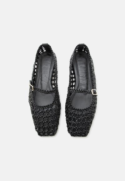Mustad punutud Mary Jane-stiilis madalad kingad ruudukujuliste varvaste ja väikeste kuldsete pandlatega rihmadel, nähtud valgel taustal ülalt vaadatuna.
