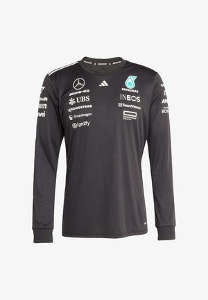 Czarna koszulka sportowa z długim rękawem wykonana z tkaniny sportowej. Posiada wiele logo, w tym Mercedes i Petronas, oraz okrągły dekolt.