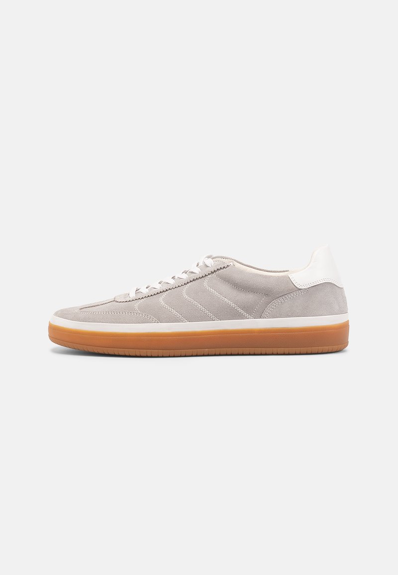 Lys grå semsket sneakers med en teksturert kropp, hvit lærsåle på hælen og såle av gummigummi. Har diagonale sømmer og snøring.