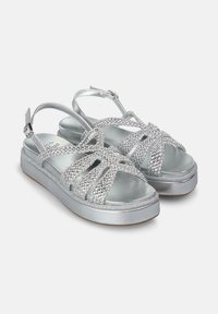 Zilveren sandalen met gevlochten banden, zachte metallic afwerking, verstelbare enkelband, platte zool en iets verhoogde hak voor comfort.