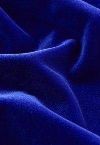 Levendig koninklijkblauw fluweel met een gladde textuur, gedrapeerd en vloeiend, dat de rijke kleurdiepte en zachte glans tentoonstelt.