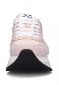 Sneaker con tomaia di un rosa chiaro in pelle scamosciata, lacci bianchi e suola in gomma nera testurizzata. Presenta un logo sulla linguetta.