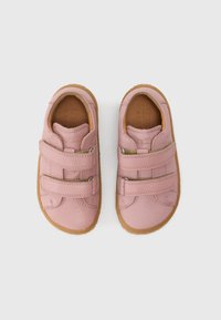 Chaussures en cuir rose avec deux brides Velcro, bout rond et finition texturée; semelle extérieure en caoutchouc marron pour l'adhérence et la durabilité.