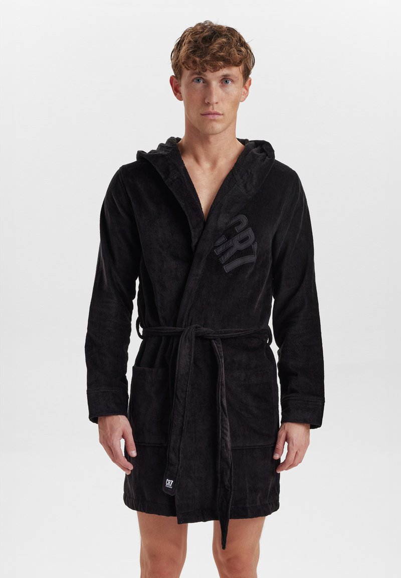 Black hooded bathrobe made of soft, textured fabric. Features a tie belt, two front pockets, and a logo on the chest.