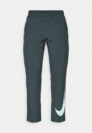 Pantaloni sportivi verde scuro con vita elastica, con il logo Nike verde menta lungo la gamba sinistra, realizzati in tessuto leggero.