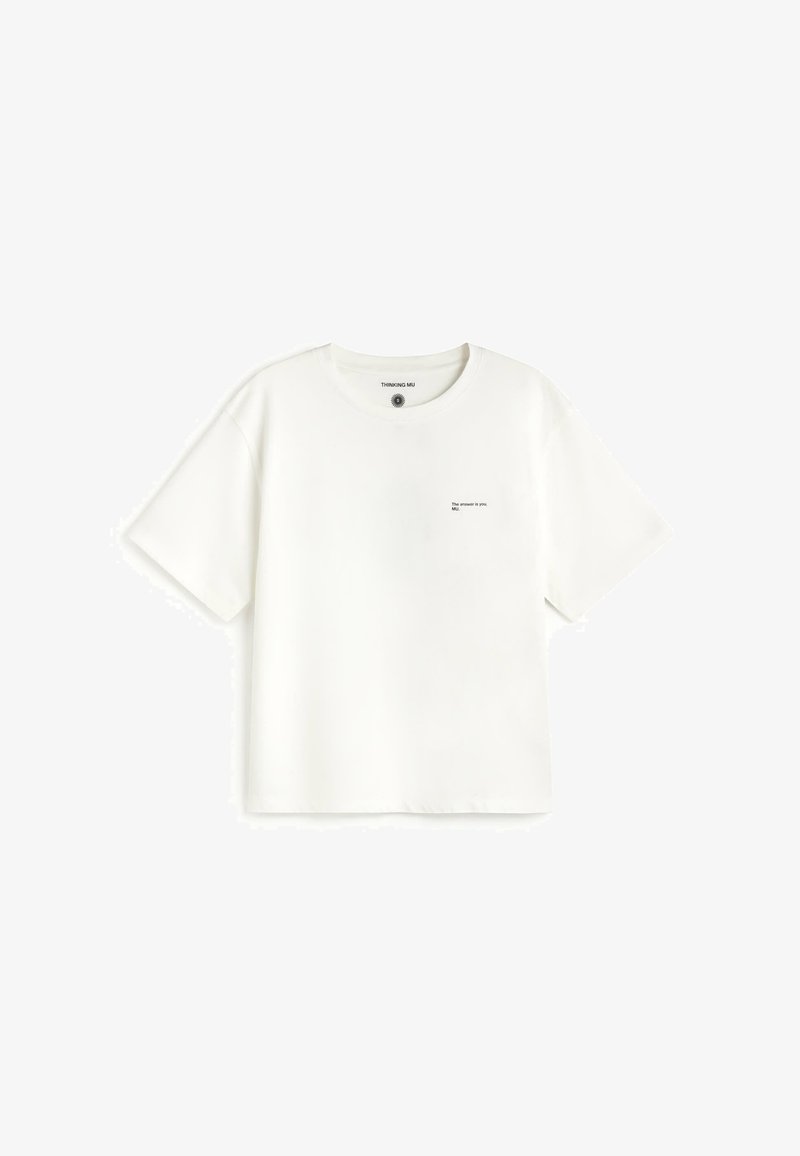 T-shirt blanc à manches courtes avec un petit texte noir sur la poitrine gauche indiquant "The answer is you, MU."