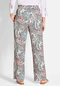 Pantalons larges imprimés dans un motif paisley pastel rose, bleu et blanc. Taille élastique avec une coupe décontractée et un tissu léger.