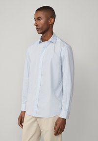 Lichtblauwe blouse met lange mouwen, met een fijne witte ruitpatroon, met een button-down kraag en een voorkant met knopen, gemaakt van katoen.