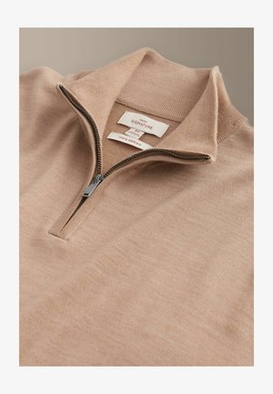 Világos bézs Merinó gyapjú pulóver magas gallérral és fél cipzárral az elején. Texturált felület, belül márkajelzésekkel.