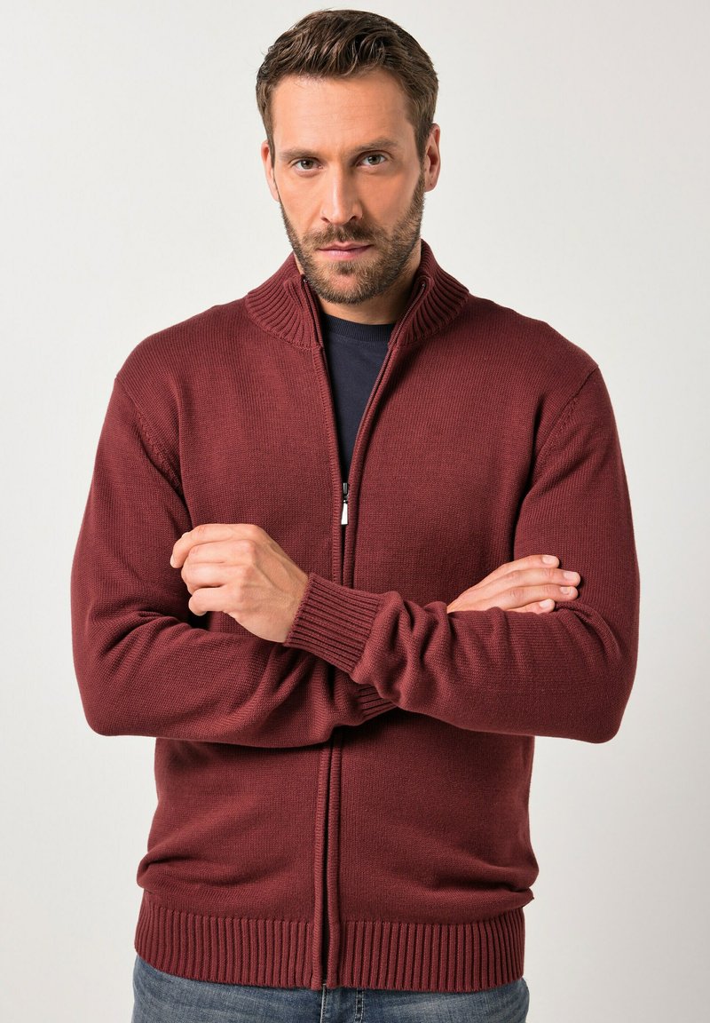 Burgundská zip-up cardigan vyrobená z texturované pleteniny, s vysokým límcem a žebrovanými manžetami a lemováním. Jednoduchý design, bez vzorů nebo akcentů.