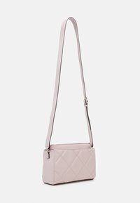 Borsa a tracolla trapuntata rosa chiaro con una lunga tracolla regolabile, forma rettangolare, texture liscia e dettagli in metallo argentato.