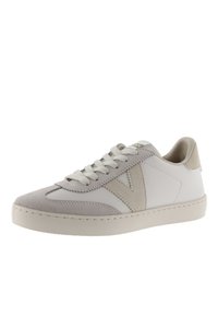 Baskets blanches avec des accents en suède gris, bout rond, dessus texturé et lacets plats. Présente un logo en 'V' sur le côté et une semelle beige clair.