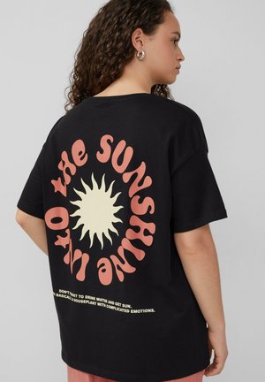 Zwarte katoenen t-shirt met een grote kleurrijke zonafbeelding op de achterkant en speelse tekst onderaan. Korte mouwen en een relaxte pasvorm.
