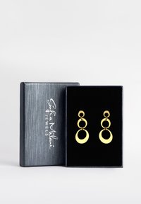 Boucles d'oreilles en or au design circulaire superposé, présentées dans une boîte noire doublée de velours avec un extérieur gris texturé.