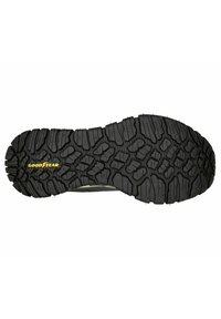 Schwarze Gummisohle mit tiefen Profilmustern, versehen mit einem gelben "GOODYEAR"-Logo. Strukturiert für verbesserten Halt und Langlebigkeit.