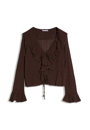 Blusa marrone a maniche lunghe con scollo a V arricciato, chiusura frontale con laccio e polsini svasati con dettagli di rifinitura delicata, distesa su sfondo bianco.