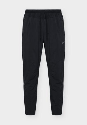 Pantaloni sportivi neri da uomo con vita regolabile con coulisse, tasche laterali con zip e piccolo logo Nike sulla coscia destra.