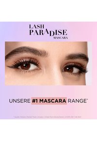 Close-up af brune øjne med lange, tykke øjenvipper fremhævet af mørk mascara og skinnende rosaguld-øjenskygge.