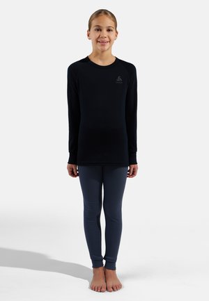 Black long-sleeve top paired with dark gray leggings; both made from stretchy, smooth fabric. Top features a small logo detail.