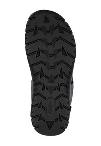 Semelle de chaussure en caoutchouc noir avec des crampons profonds et agressifs et des motifs triangulaires pour une meilleure adhérence. Présente une étiquette de marque au centre.